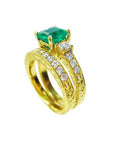 Displaying a bridal wedding band and the matching emerald ring together side profile. 