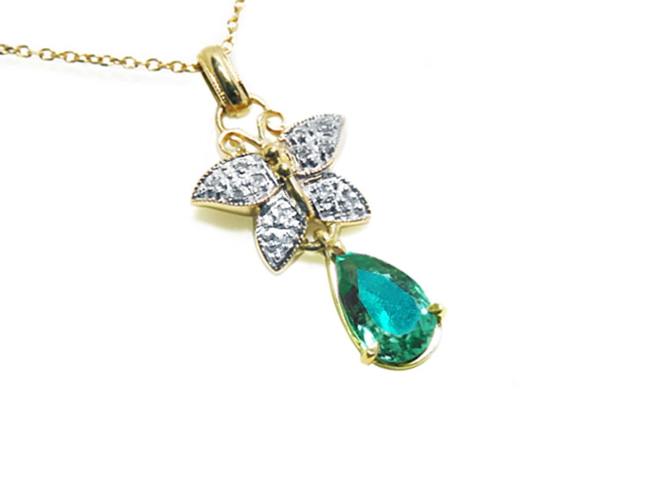 Gold butterfly pendant with natural teardrop emerald and diamond accents on a right position topside view.