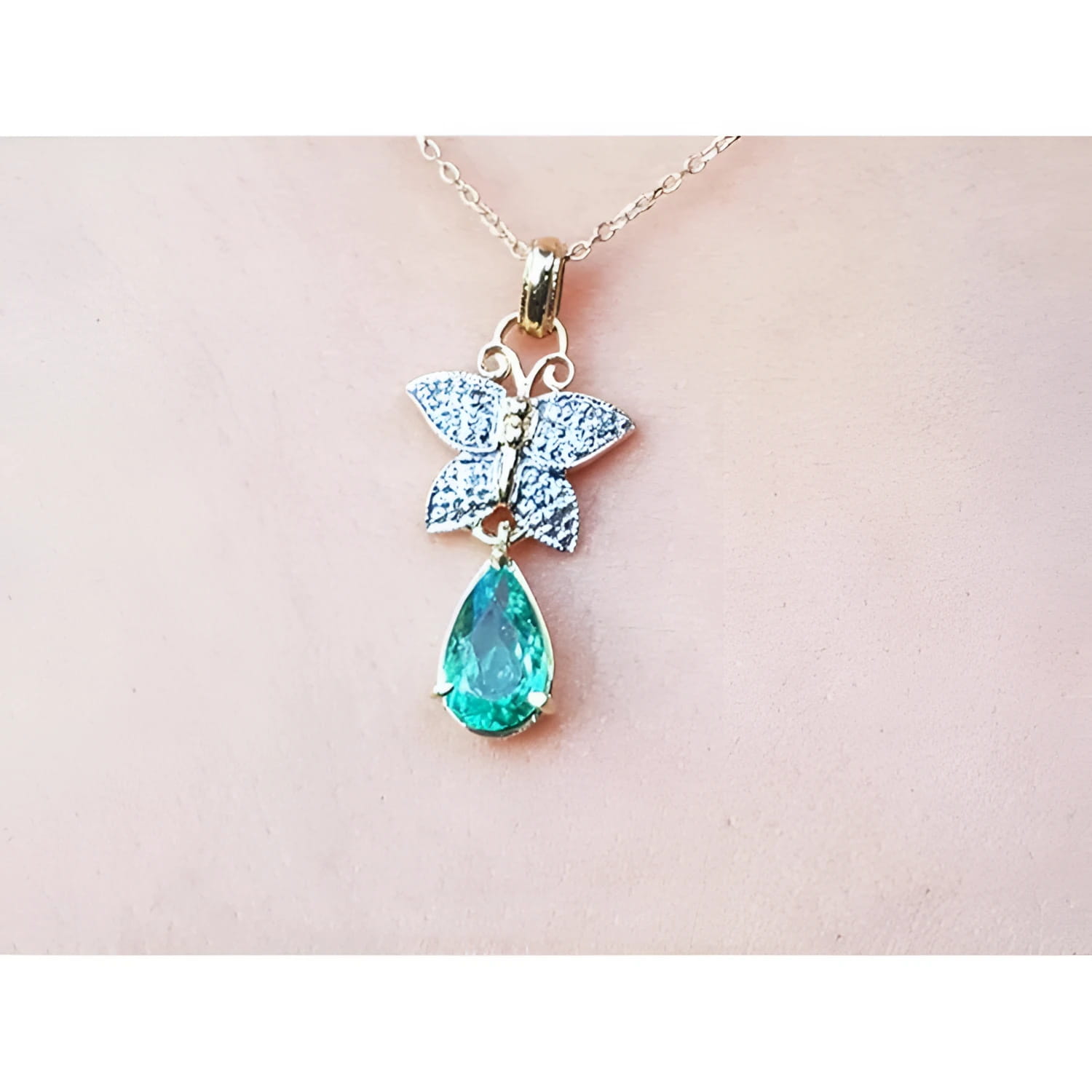 14K gold butterfly pendant with pavé diamonds and a pear-shaped Colombian emerald.