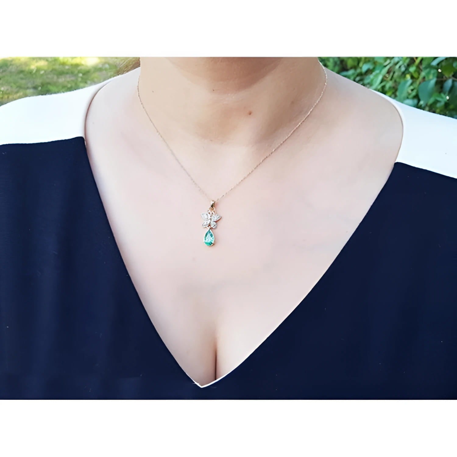 14K gold butterfly pendant with pavé diamonds and a pear-shaped Colombian emerald.