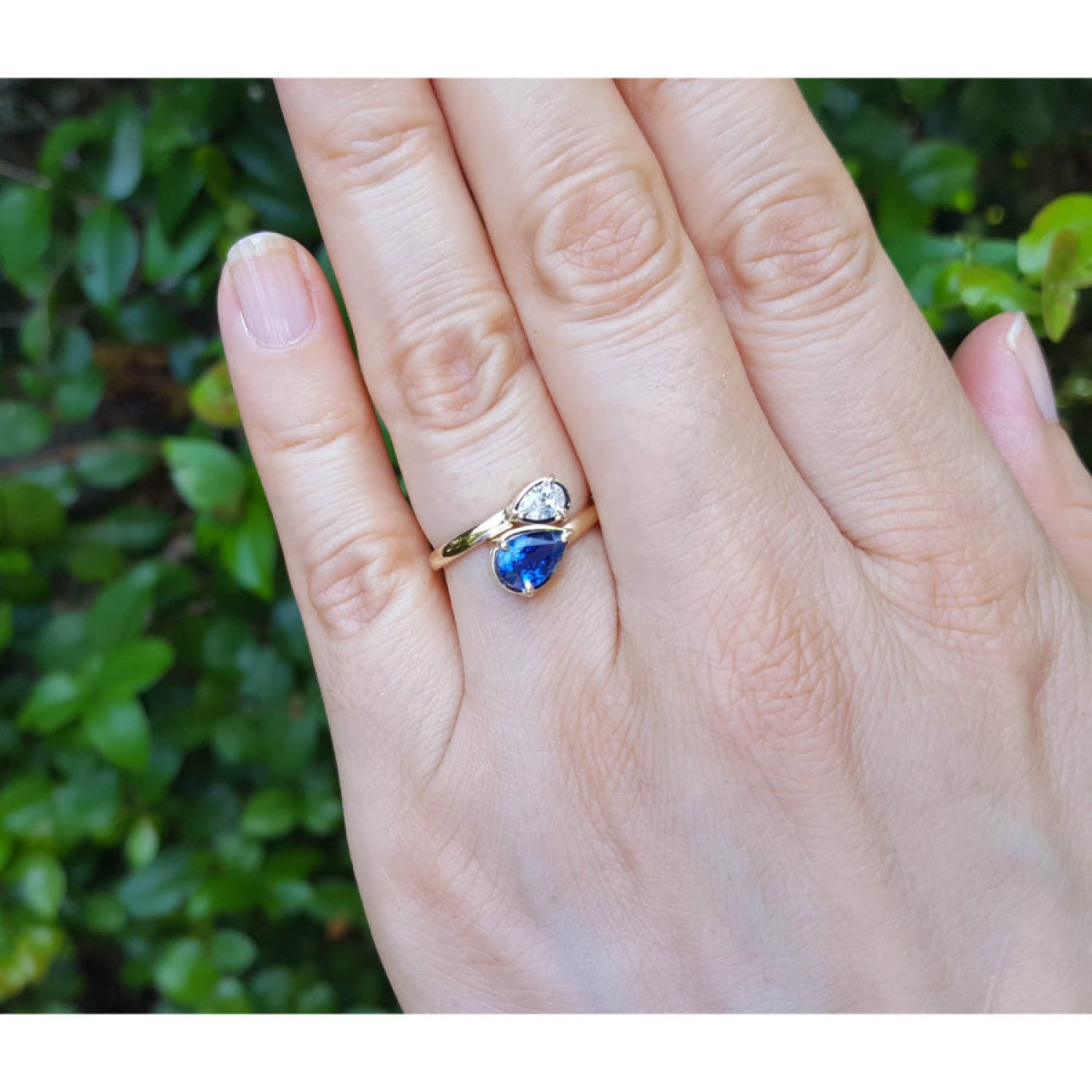 Women's Two-stone "You and Me" blue natural sapphire bypass ring, handcrafted in 18k yellow gold with its distinctive twisted-band silhouette.