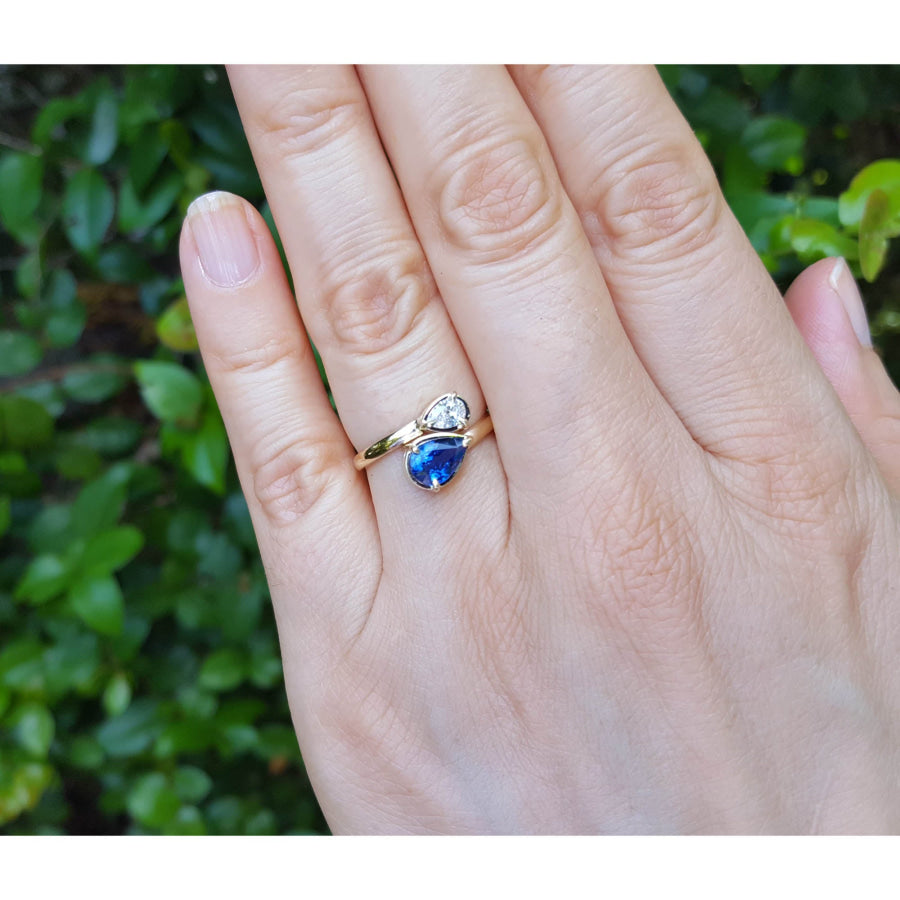 Women's Two-stone "You and Me" blue natural sapphire bypass ring, handcrafted in 18k yellow gold with its distinctive twisted-band silhouette.