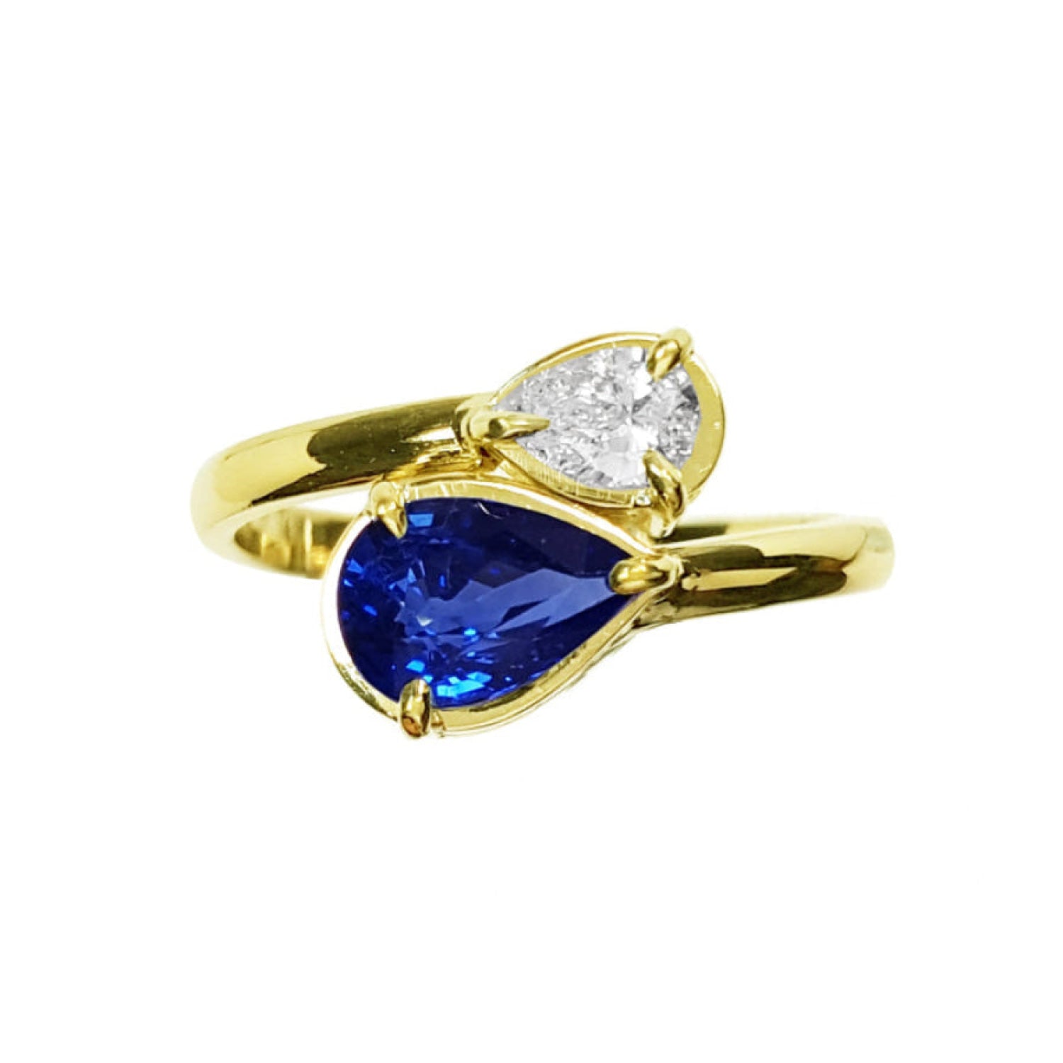 A 18k yellow gold bypass ring toi et moi design a pear-cut blue sapphire and a smaller pear-cut diamond.