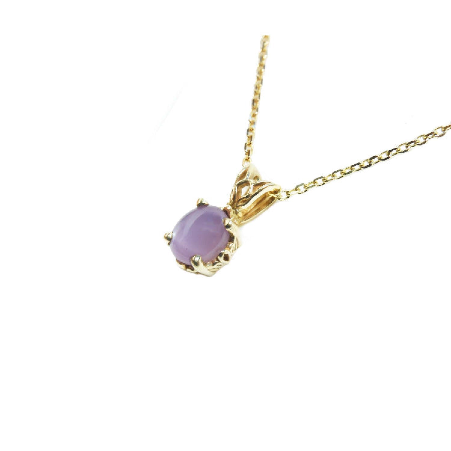 Necklace with a cabochon oval cut pink sapphire pendant in 14k yellow gold.