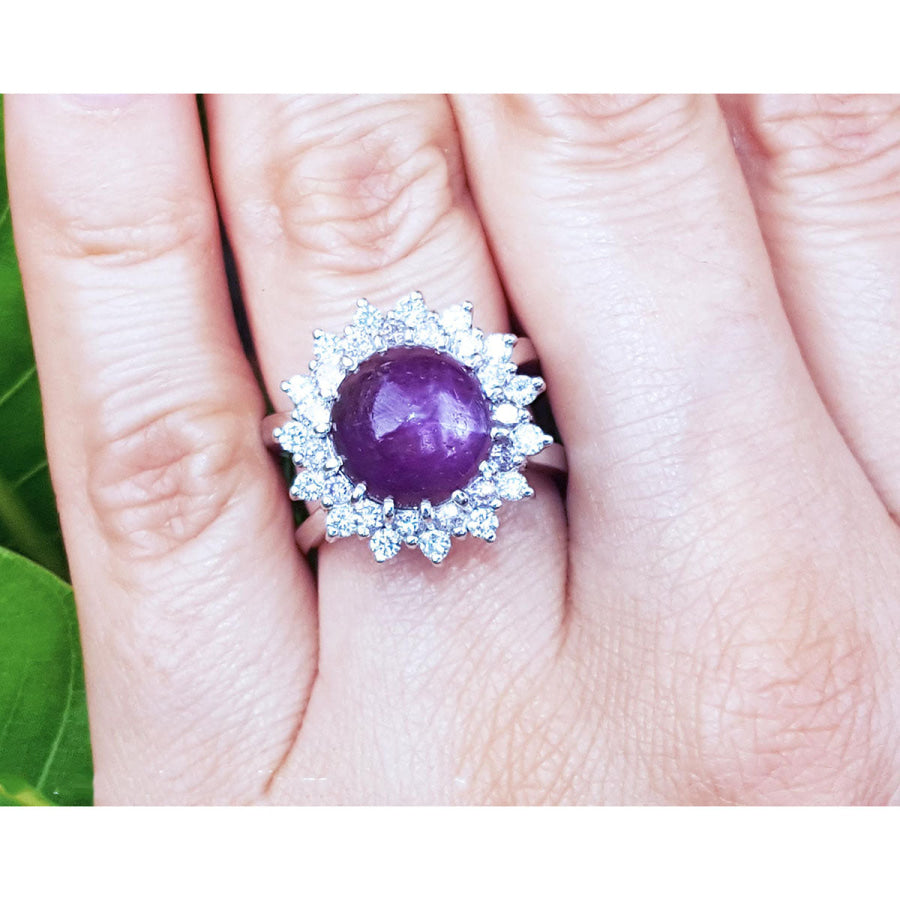 Red purple cabochon star ruby women's ring front top view in a double halo natural diamonds on a hand