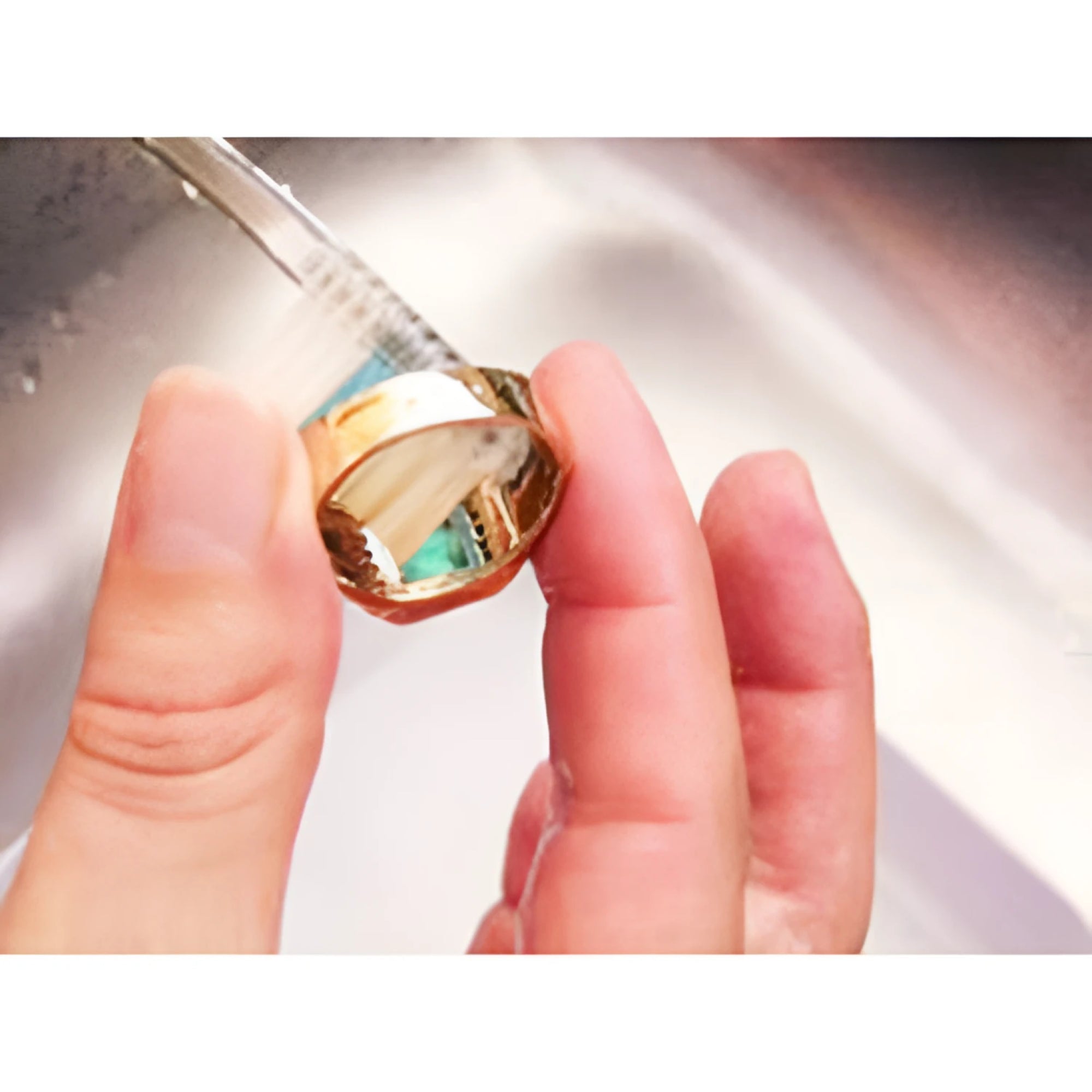 Brushing emerald ring underside to remove dirt 