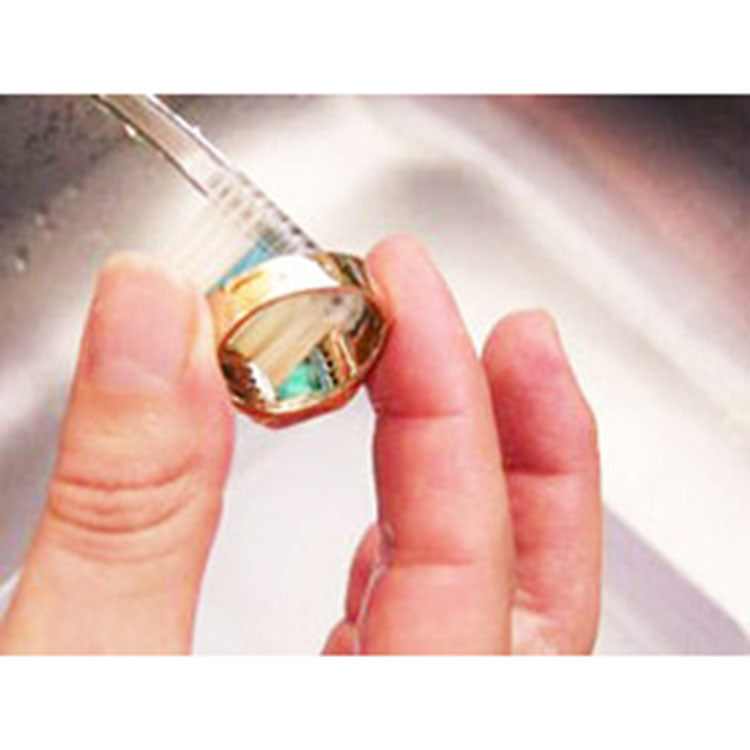 Brushing emerald ring underside to remove dirt 