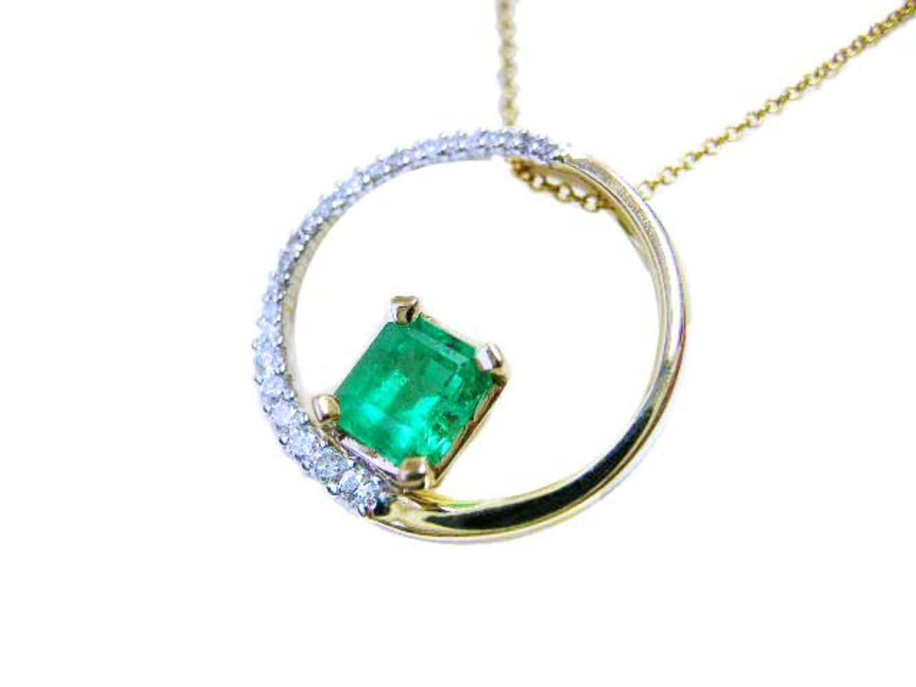 Gold necklace meaning the circle of life with a natural emerald and circular design on a white background.