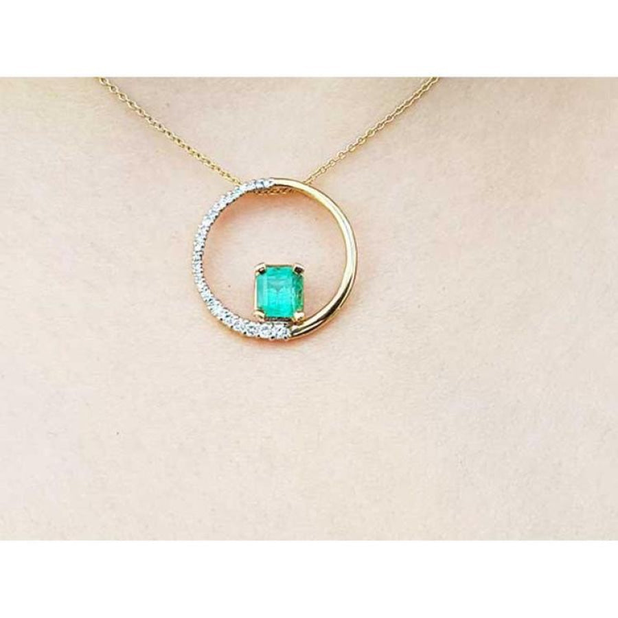 14K gold "Circle of Life" pendant with a rectangular emerald center stone and half pavé diamonds.