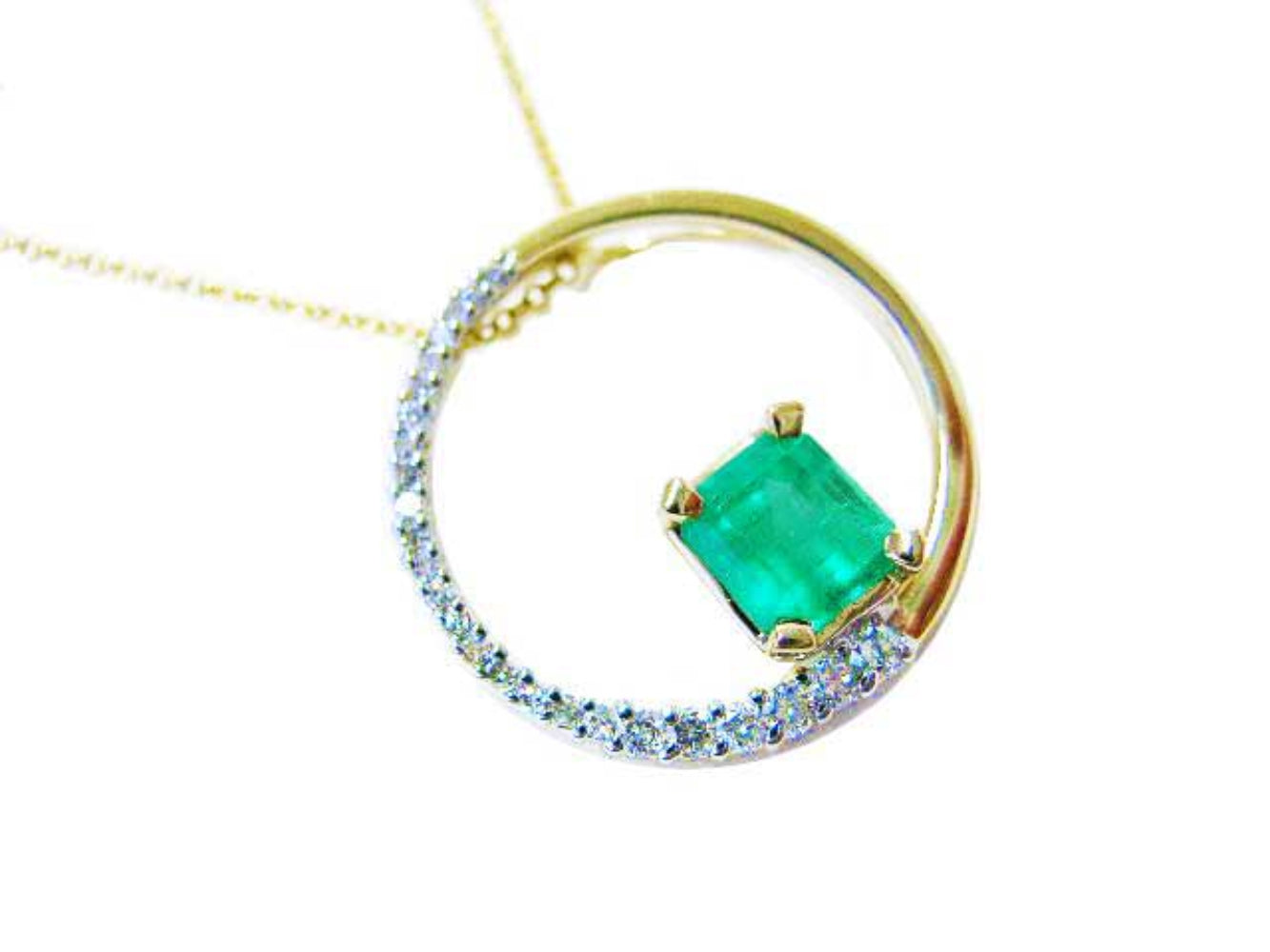 The circle of life with a genuine Colombian emerald pendant necklace, topside view, half diamonds and half gold.