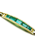 Gold bracelet with five high qualities natural colombian emeralds and side diamonds on a white background.
