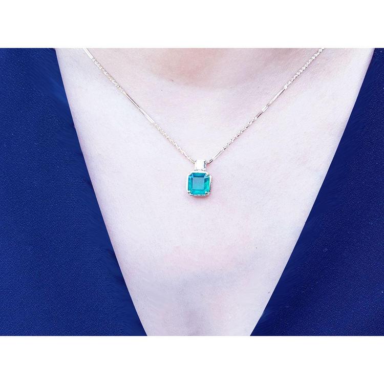 Asscher cut Colombian emerald necklace with a princess cut diamond on an 18K yellow gold chain.