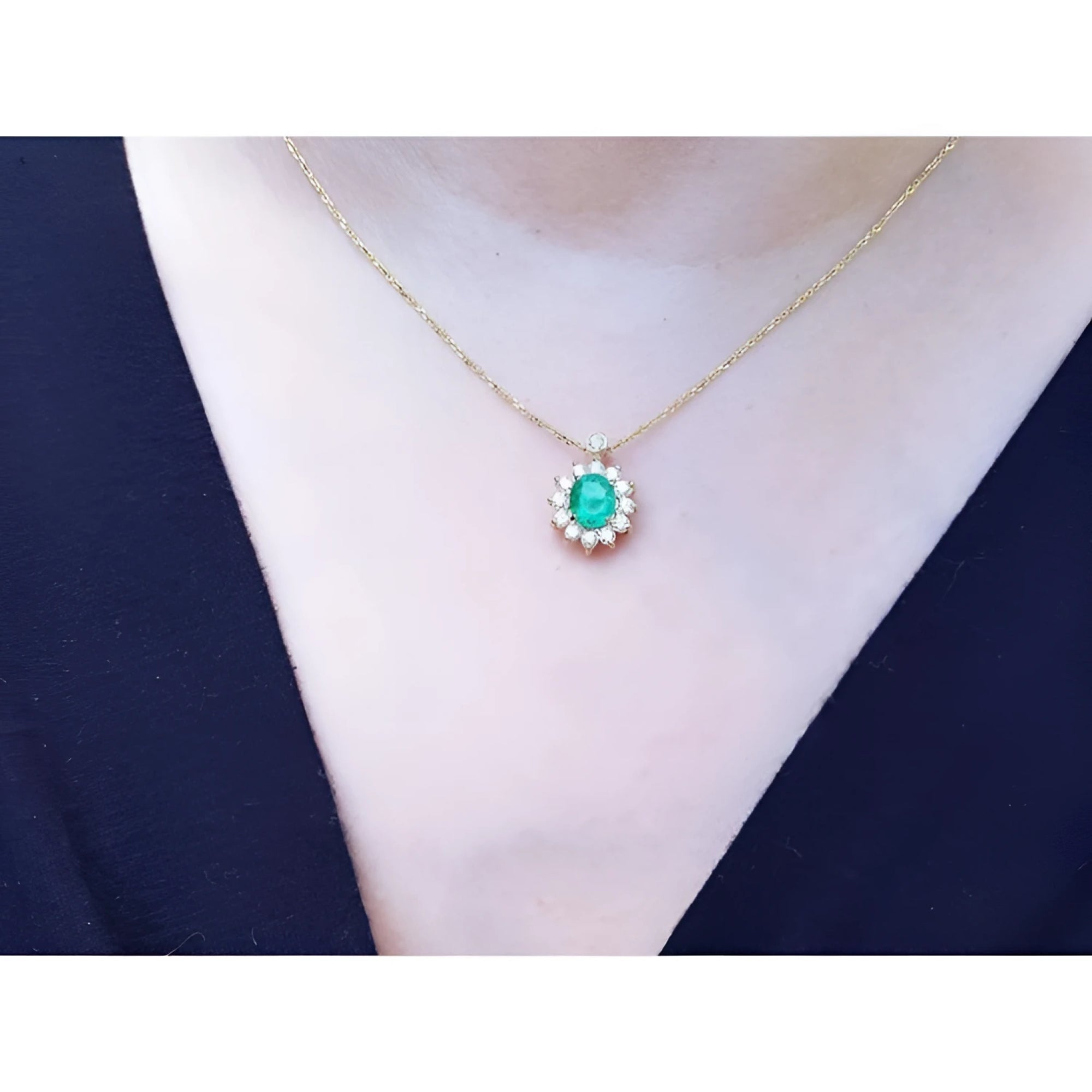 Oval cut emerald and natural diamond pendant on a delicate 14K yellow gold chain.