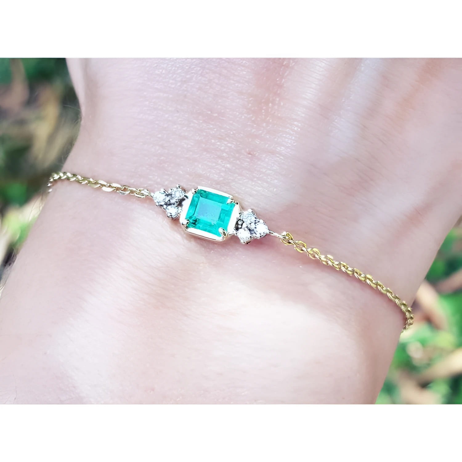 Women's 14k yellow gold bracelet with a 0.85 ct emerald and six natural diamonds.