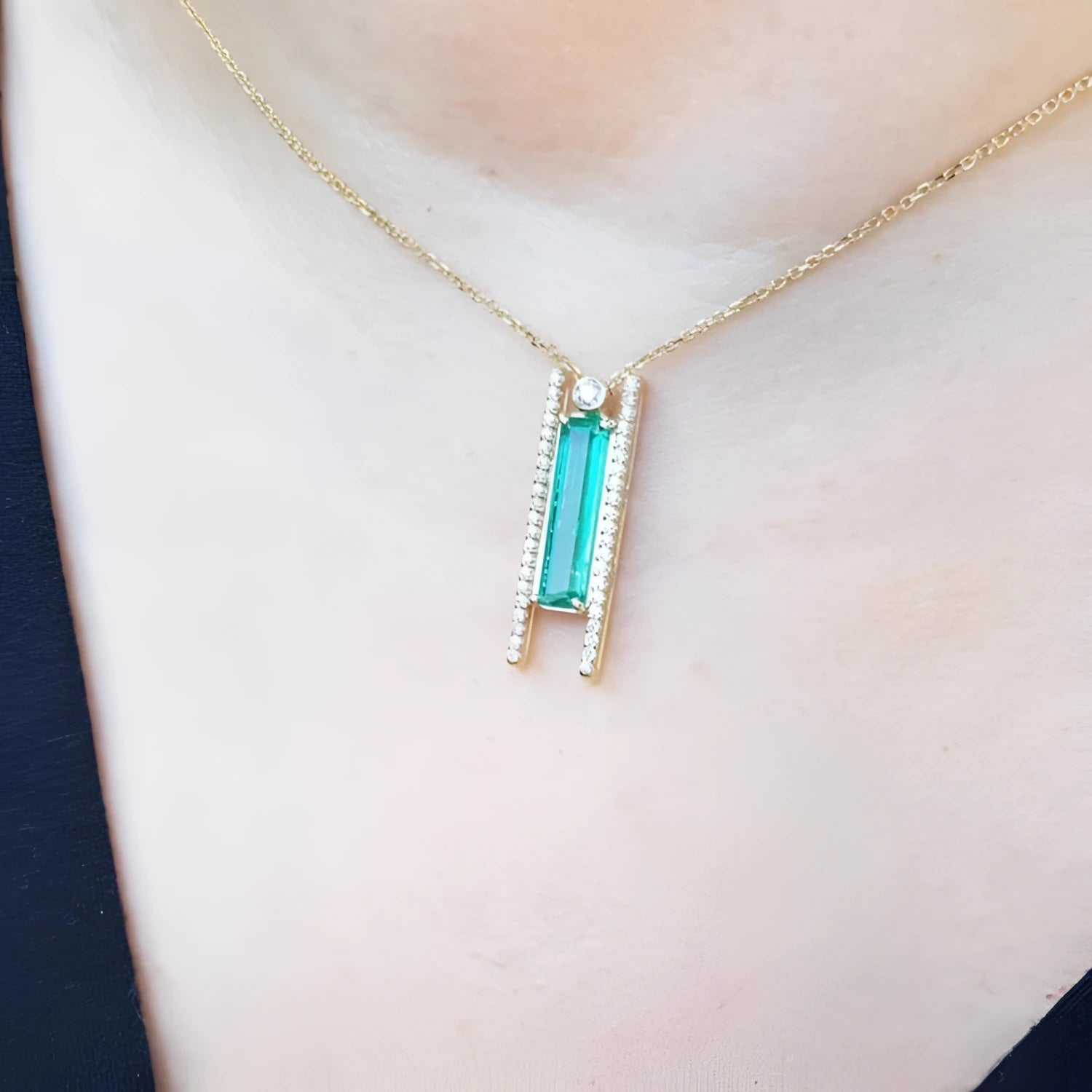 Emerald baguette cut necklace with natural diamonds, 14K yellow gold chain, and unique sliding tube bail.