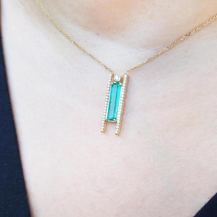Emerald baguette cut necklace with natural diamonds, 14K yellow gold chain, and unique sliding tube bail.