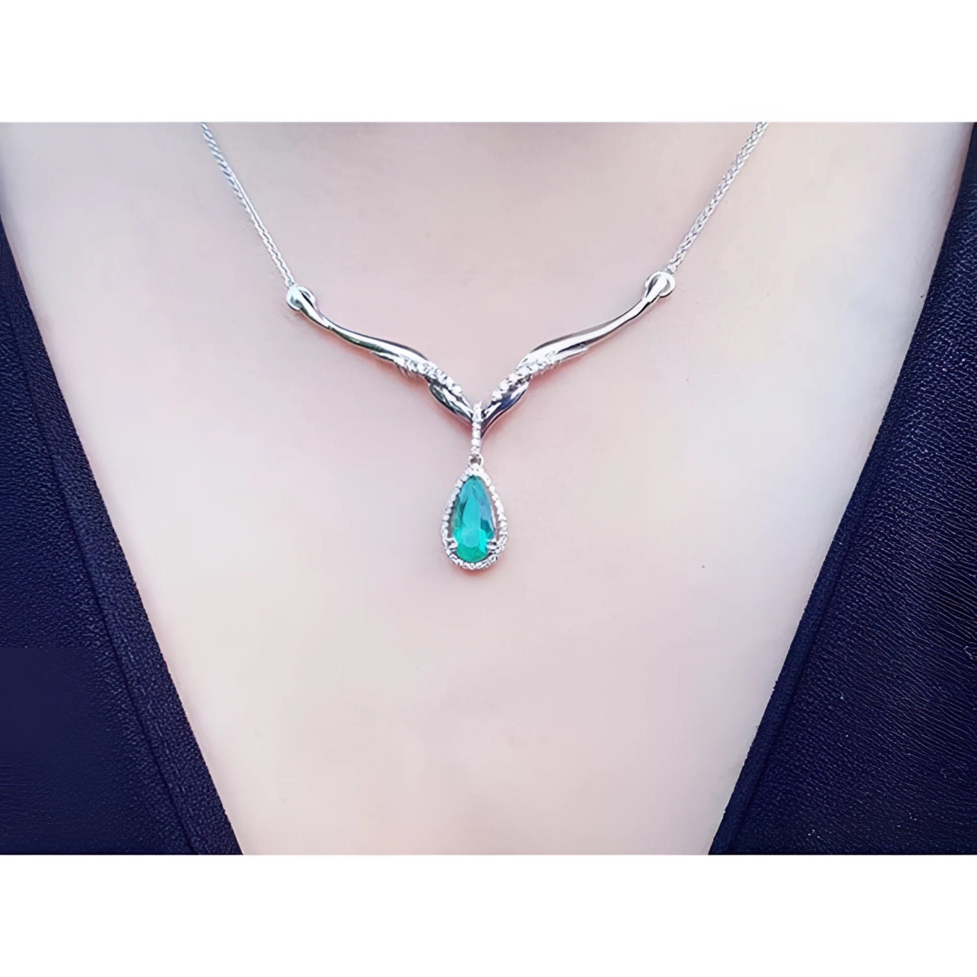 1.28 carat pear cut emerald necklace with diamonds on a 14K white gold entwined chevron design.