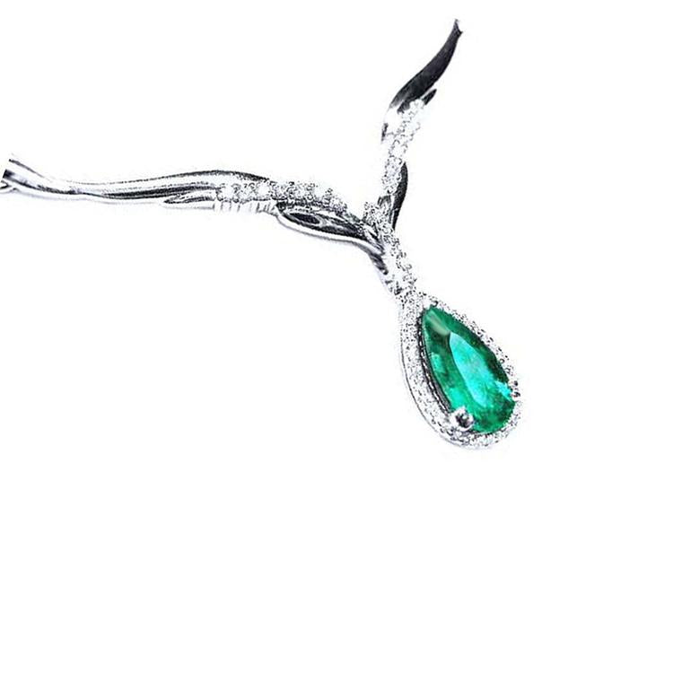 Pear cut emerald necklace sourced from Muzo mines in a halo diamond crafted in 14k white gold.