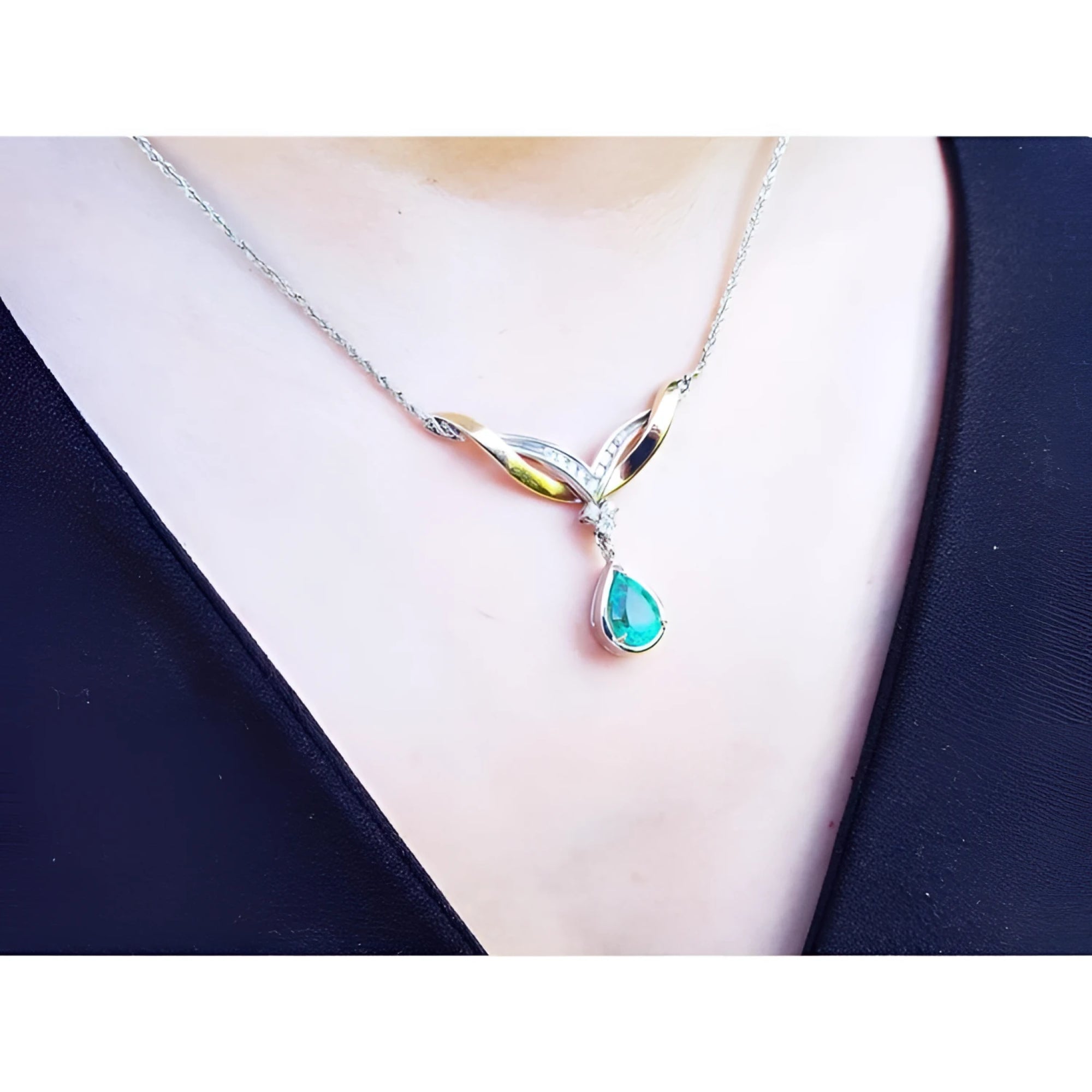 14K white/yellow gold necklace with a pear-shaped Colombian emerald and diamond chevron design.