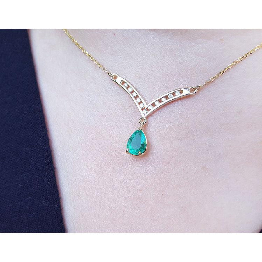 1.01 carat pear cut emerald necklace with accent diamonds set in 14K yellow gold.