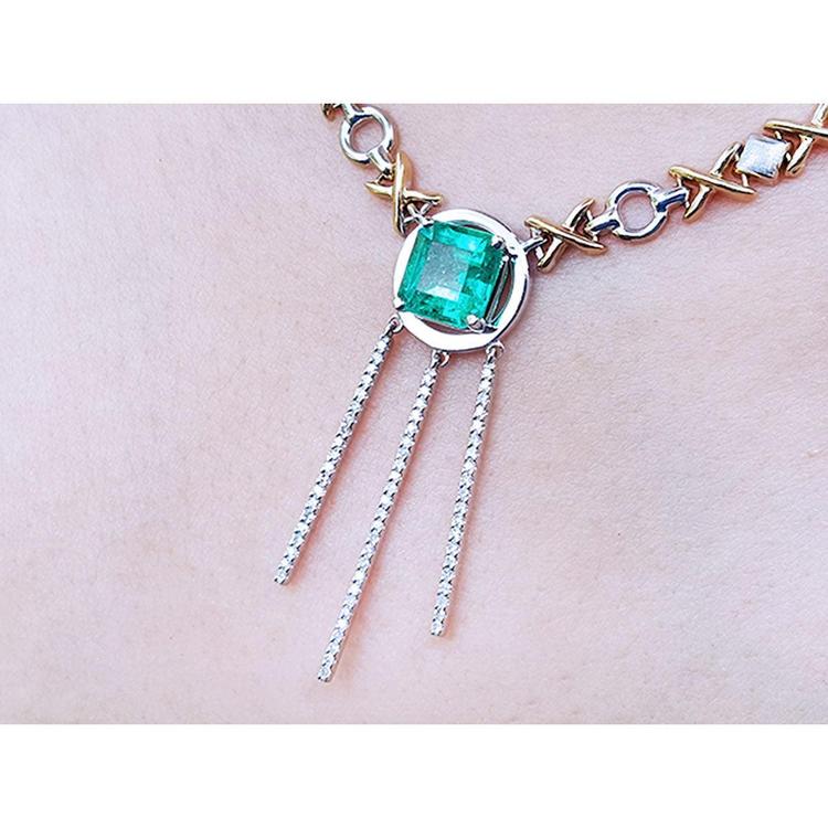 14K white and yellow gold Kisses and Hugs necklace with a square emerald and three dangling chains.