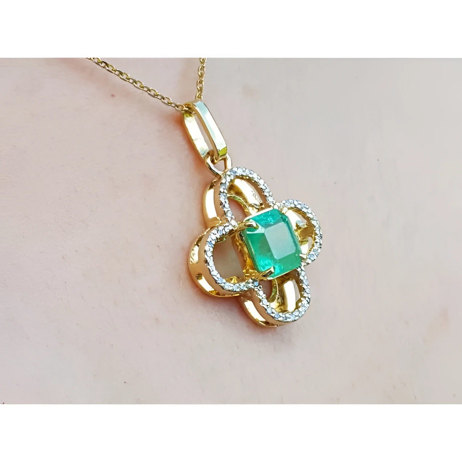 14K gold clover pendant with a square emerald and diamond accents on a delicate chain.