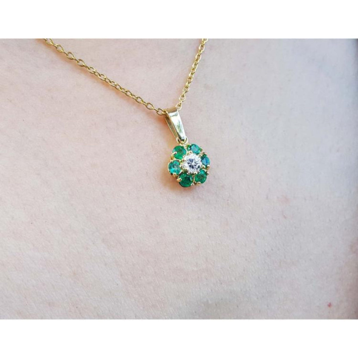 18K yellow gold cluster pendant with natural Colombian emeralds and a center diamond.