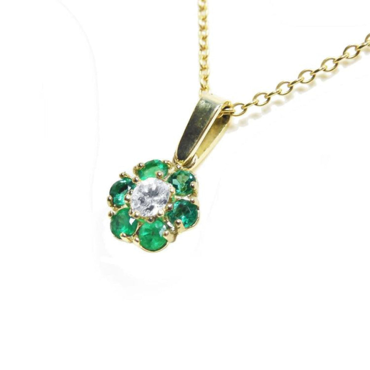 18K yellow gold cluster pendant with a center diamond surrounded by emeralds on a chain.