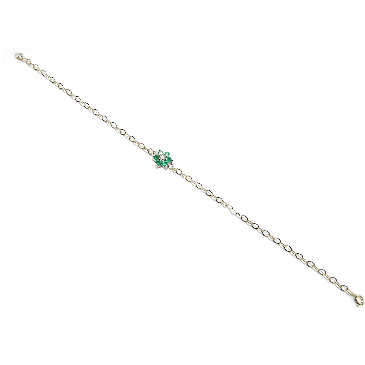 Gold bracelet with a emerald cluster on a distant view.