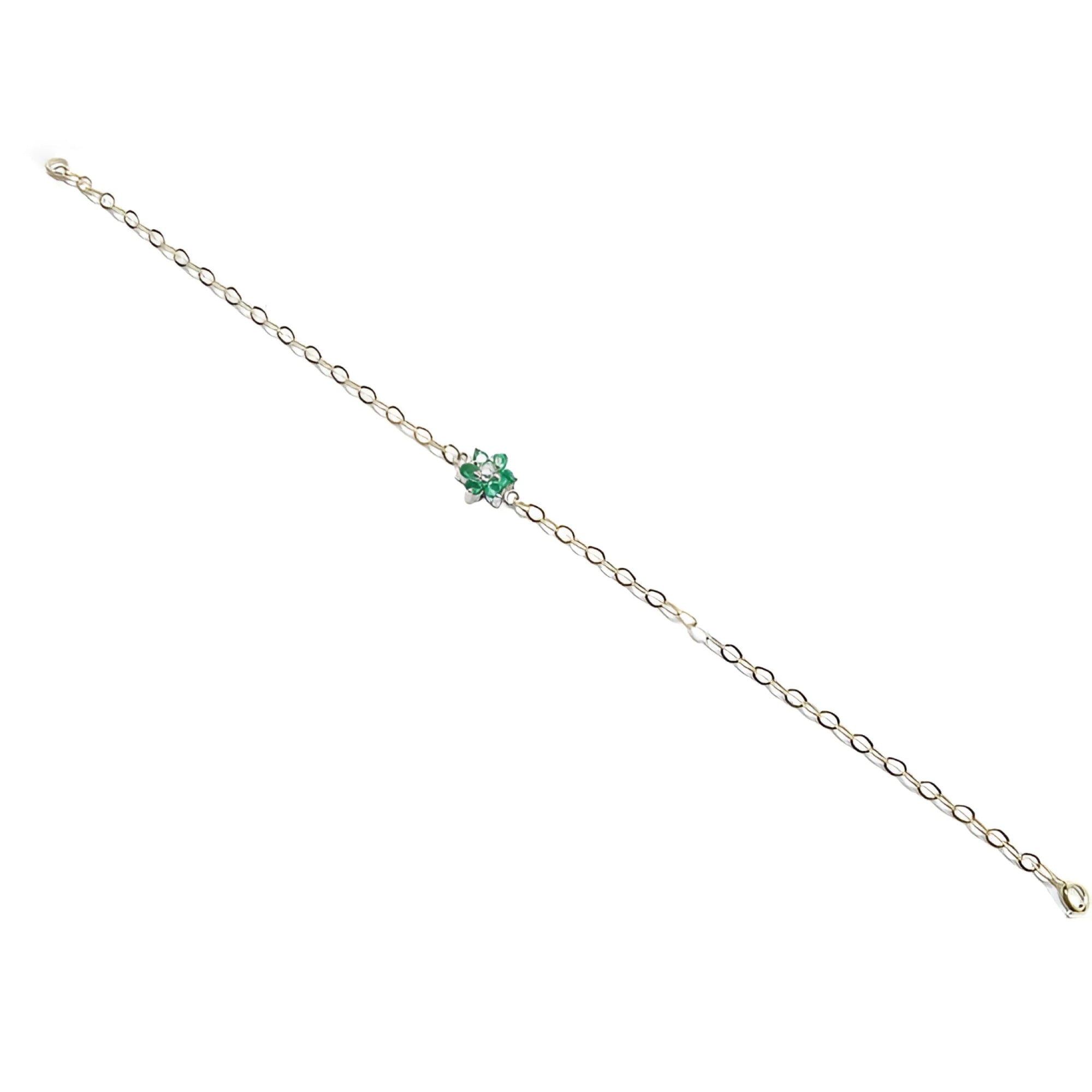 14K yellow gold bracelet with a central cluster of six green emeralds and one diamond.