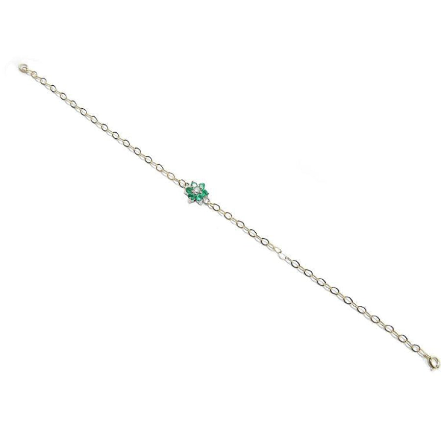 14K yellow gold bracelet with a central cluster of six green emeralds and one diamond.