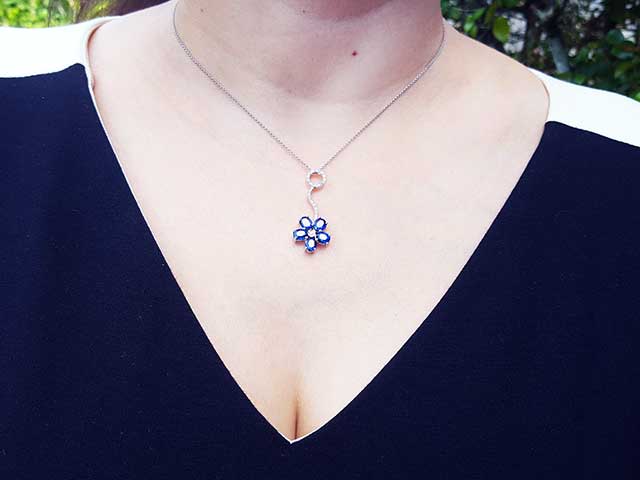 A woman wearing a cluster of natural sapphires pendant white gold necklace on outdoor 