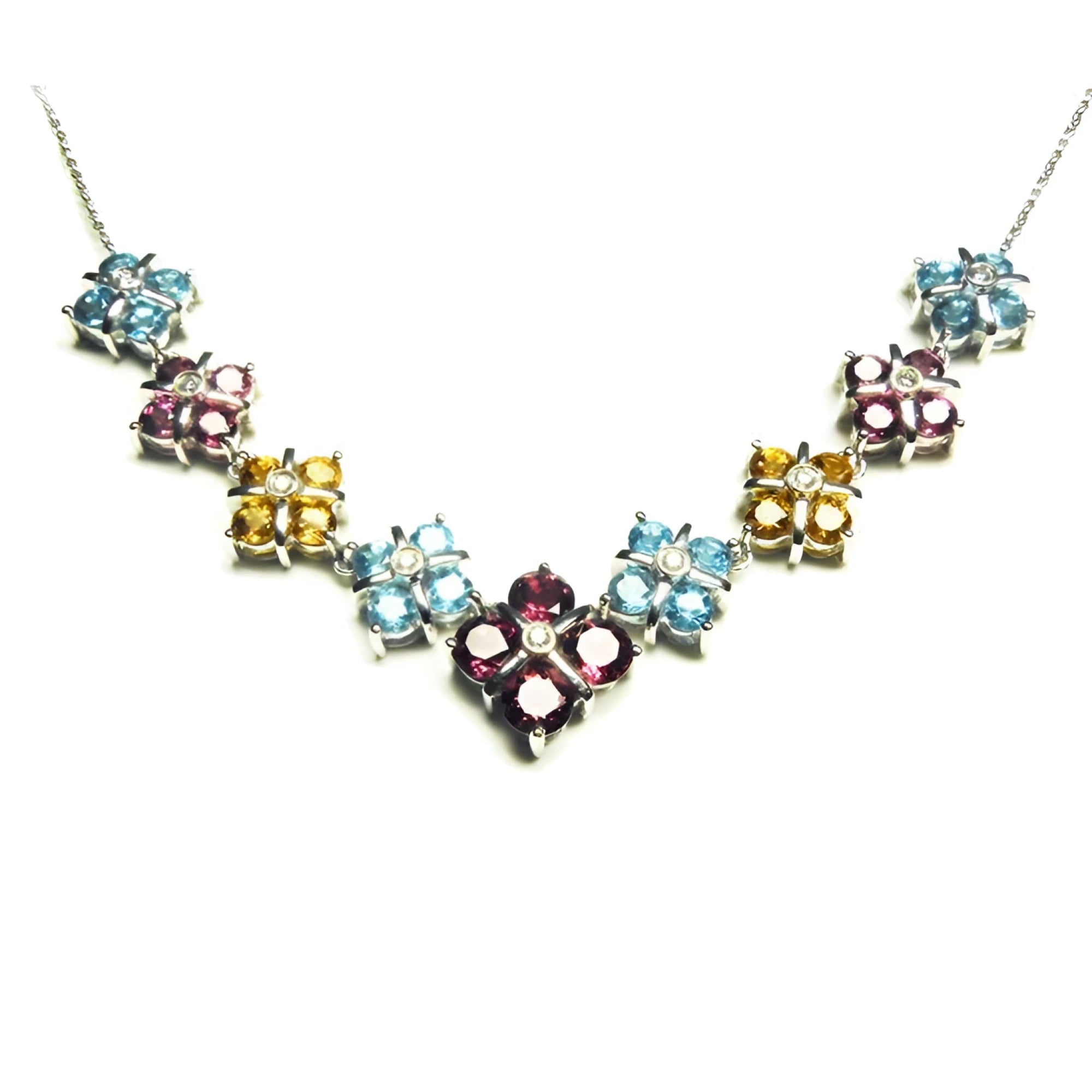 18K white gold necklace with tri-colored topaz X-cluster links and a diamond accent.