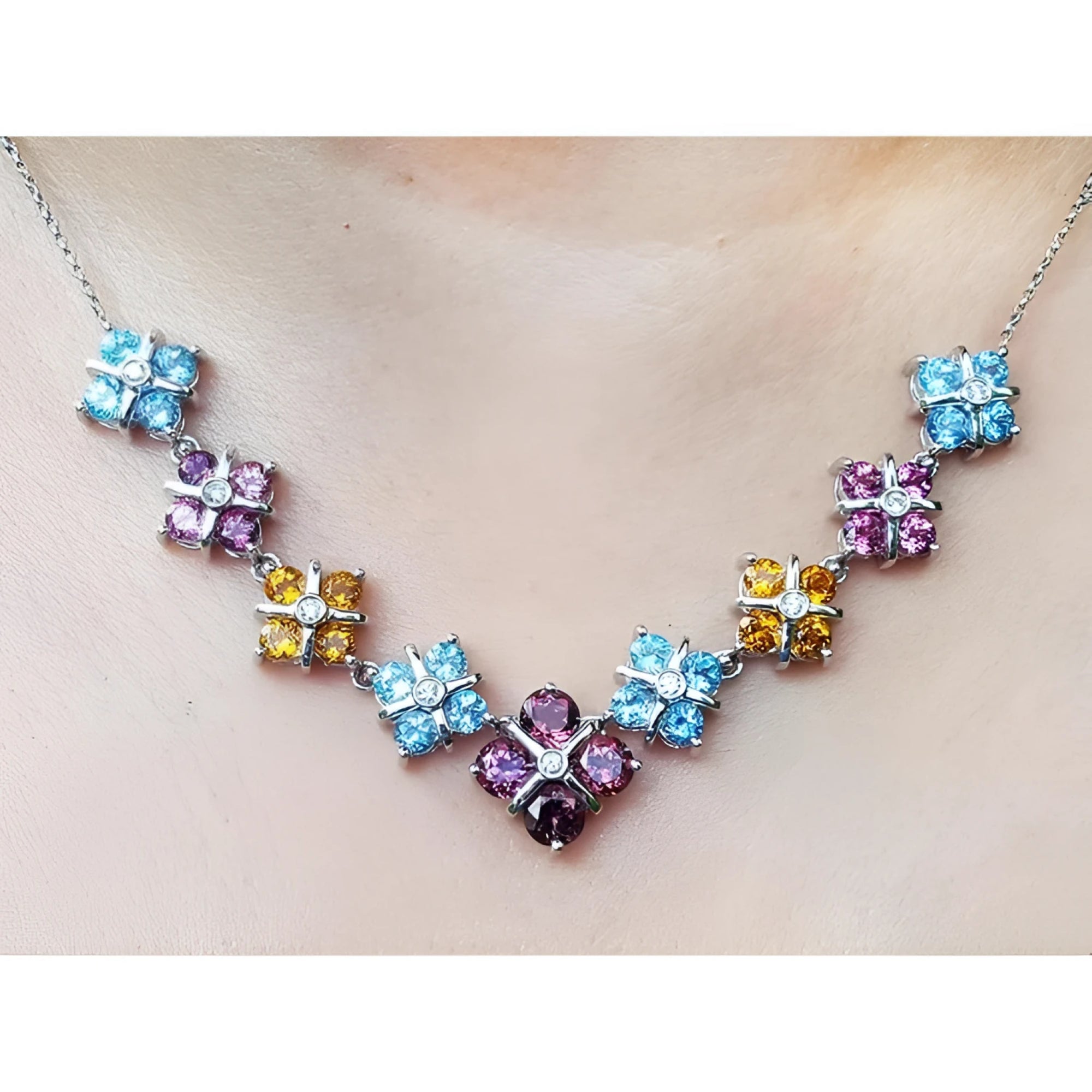 18K white gold necklace with tri-colored topaz X-cluster links and a central diamond.