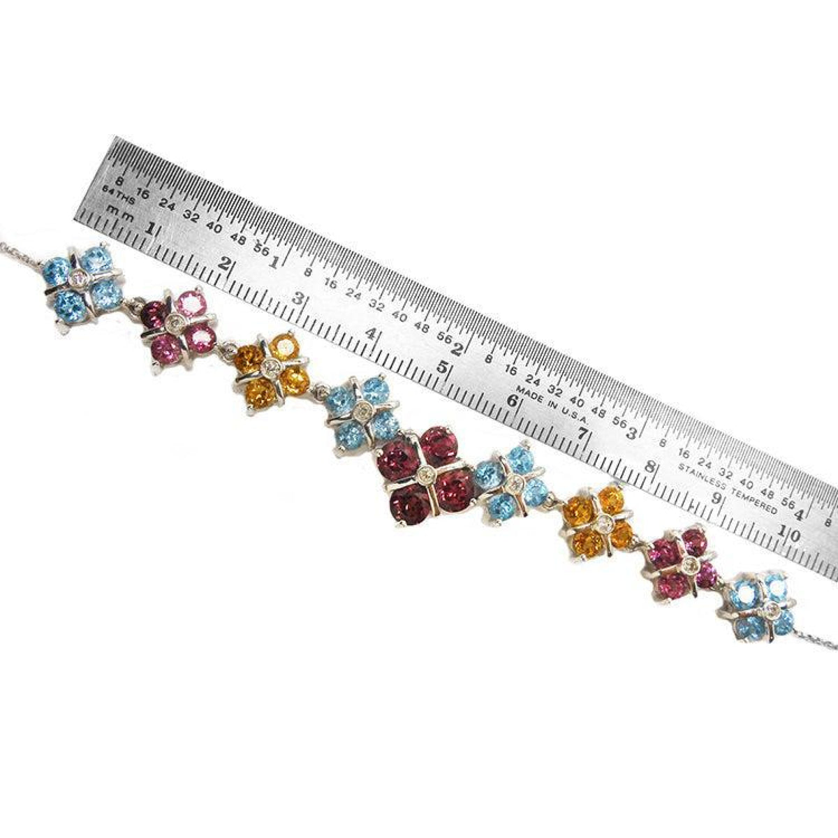 18K white gold necklace with X-cluster links, tri-colored topaz, and diamond, measured by a ruler.