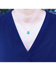 Asscher cut Colombian emerald necklace with a princess cut diamond on an 18K yellow gold chain.