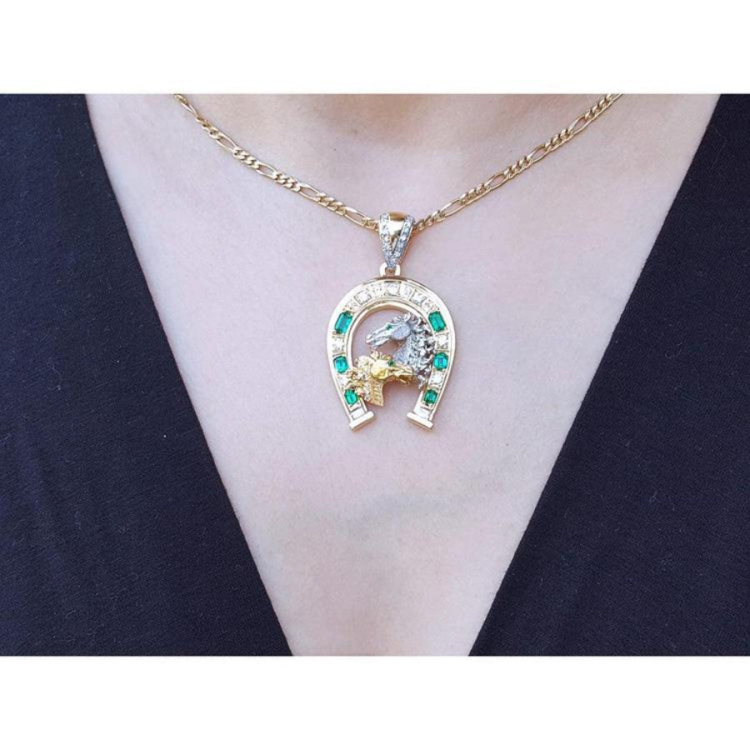 18K yellow gold horseshoe pendant with emeralds, diamonds, and horse head design on a necklace.