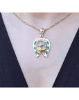 18K yellow gold horseshoe pendant with emeralds, diamonds, and horse head design on a necklace.
