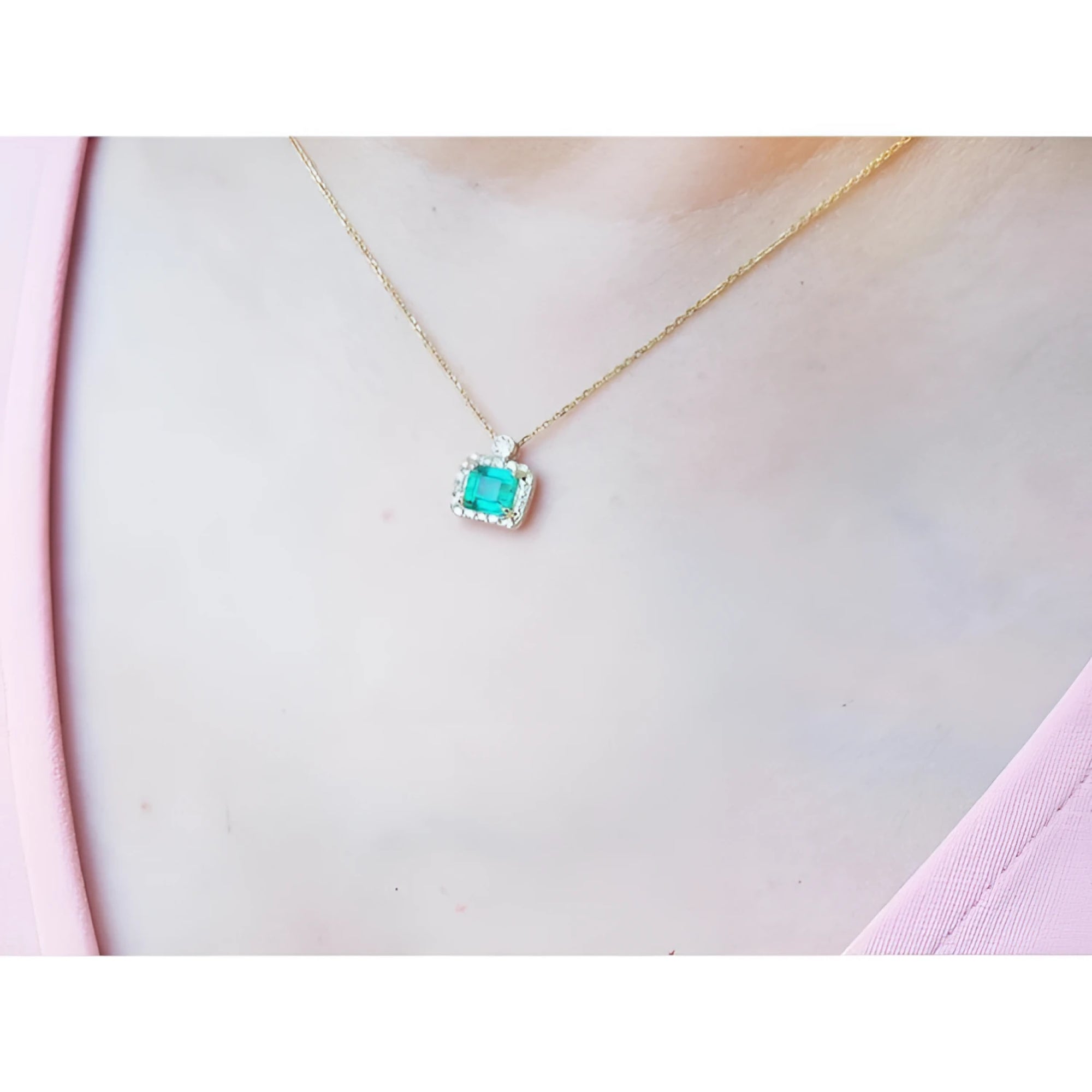 1.31 ct emerald-cut Muzo Colombian emerald necklace with diamonds in 14K yellow gold on a model.