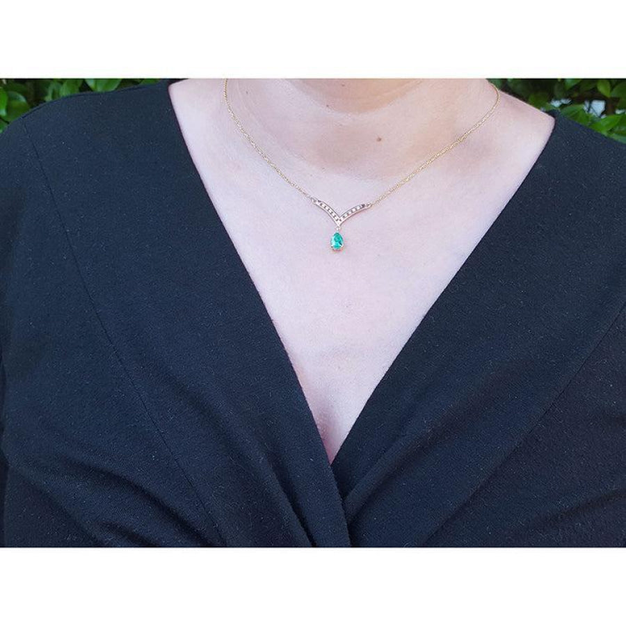 1.01 carat pear cut emerald necklace with accent diamonds and 14K yellow gold V chevron design.