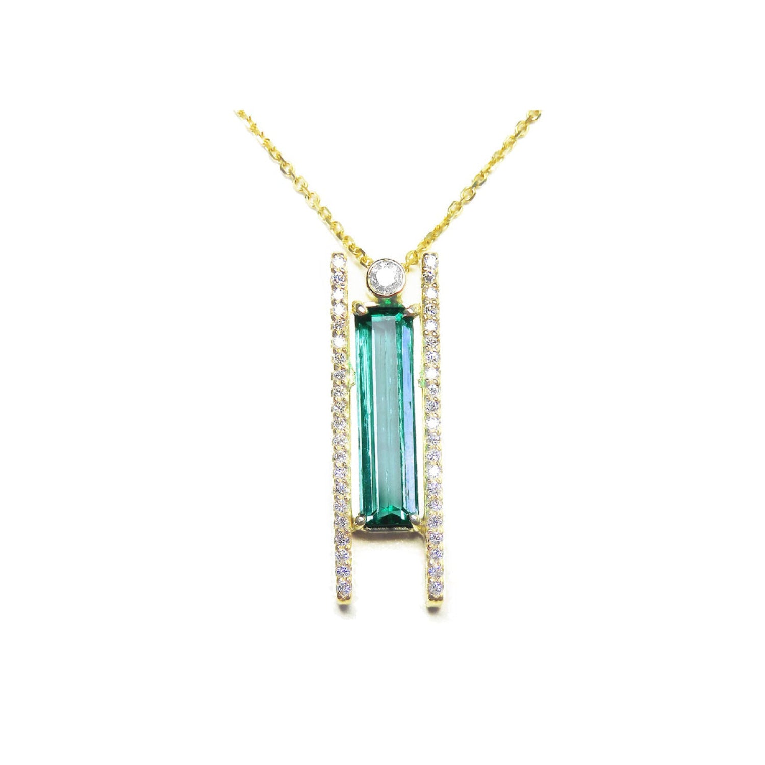 14K yellow gold necklace with a baguette-cut emerald, accent diamonds, and a sliding tube bail flanked by vertical rows of diamonds, suspended from a delicate gold chain.