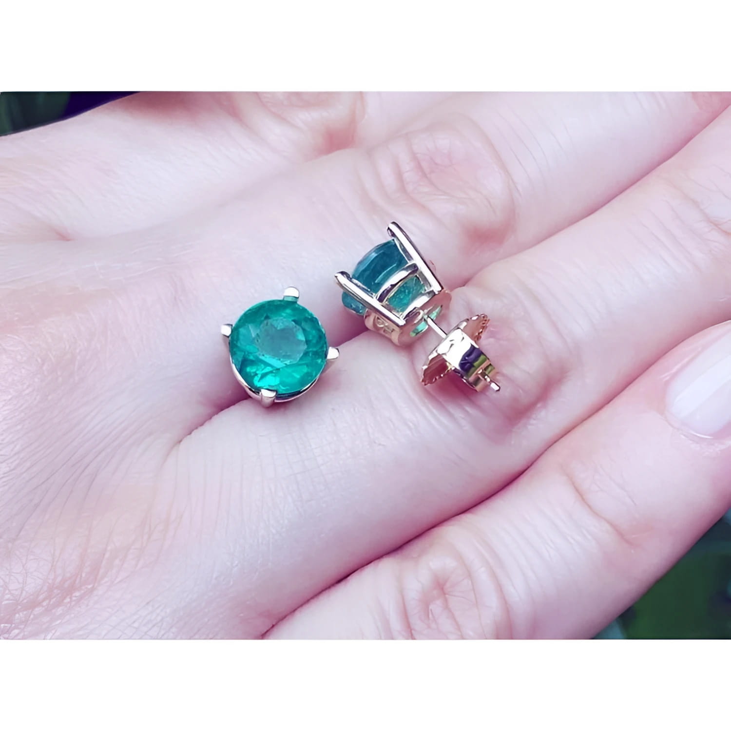 Colombian emerald stud earrings, round cut, bluish-green, in 14K yellow gold prong settings.