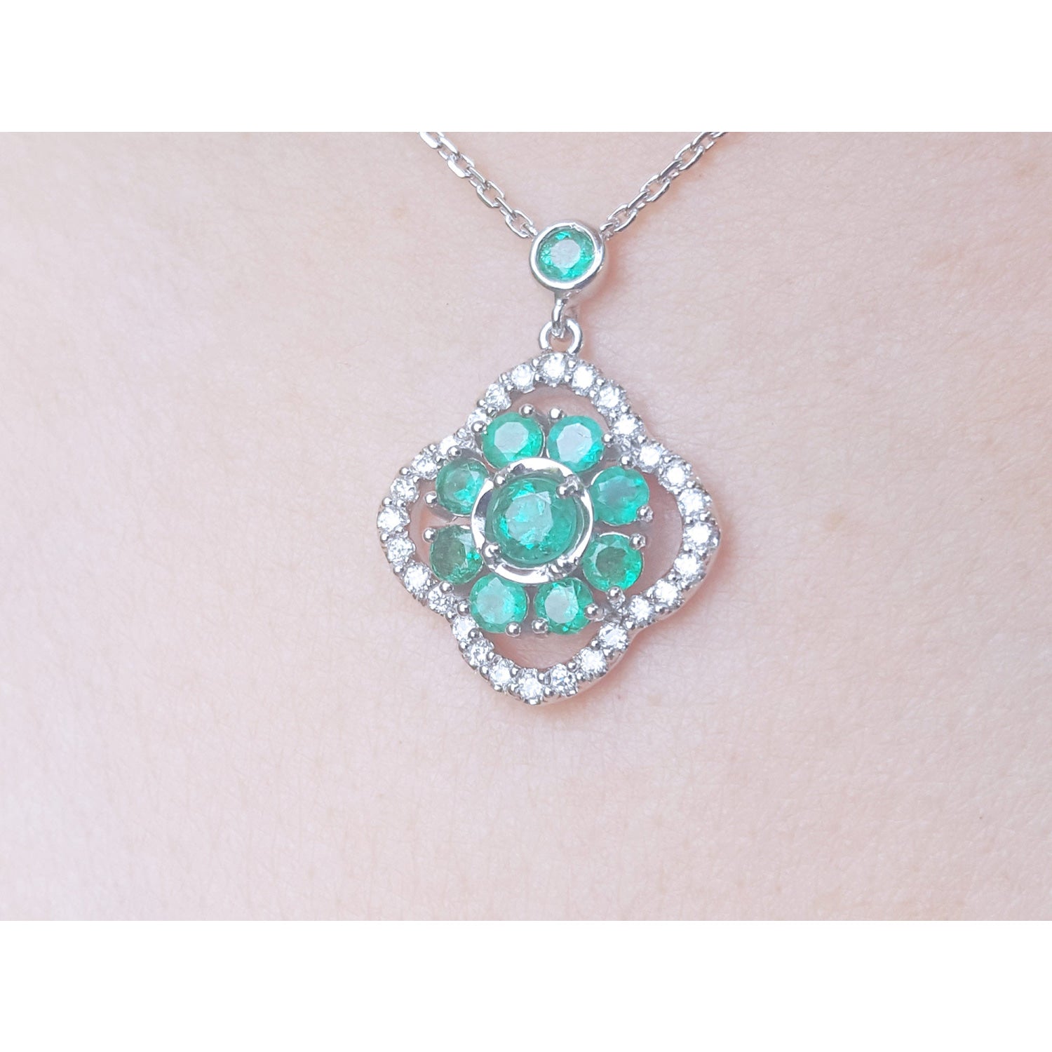 14K white gold cluster necklace with natural Colombian emeralds and diamond 4-leaf clover silhouette.