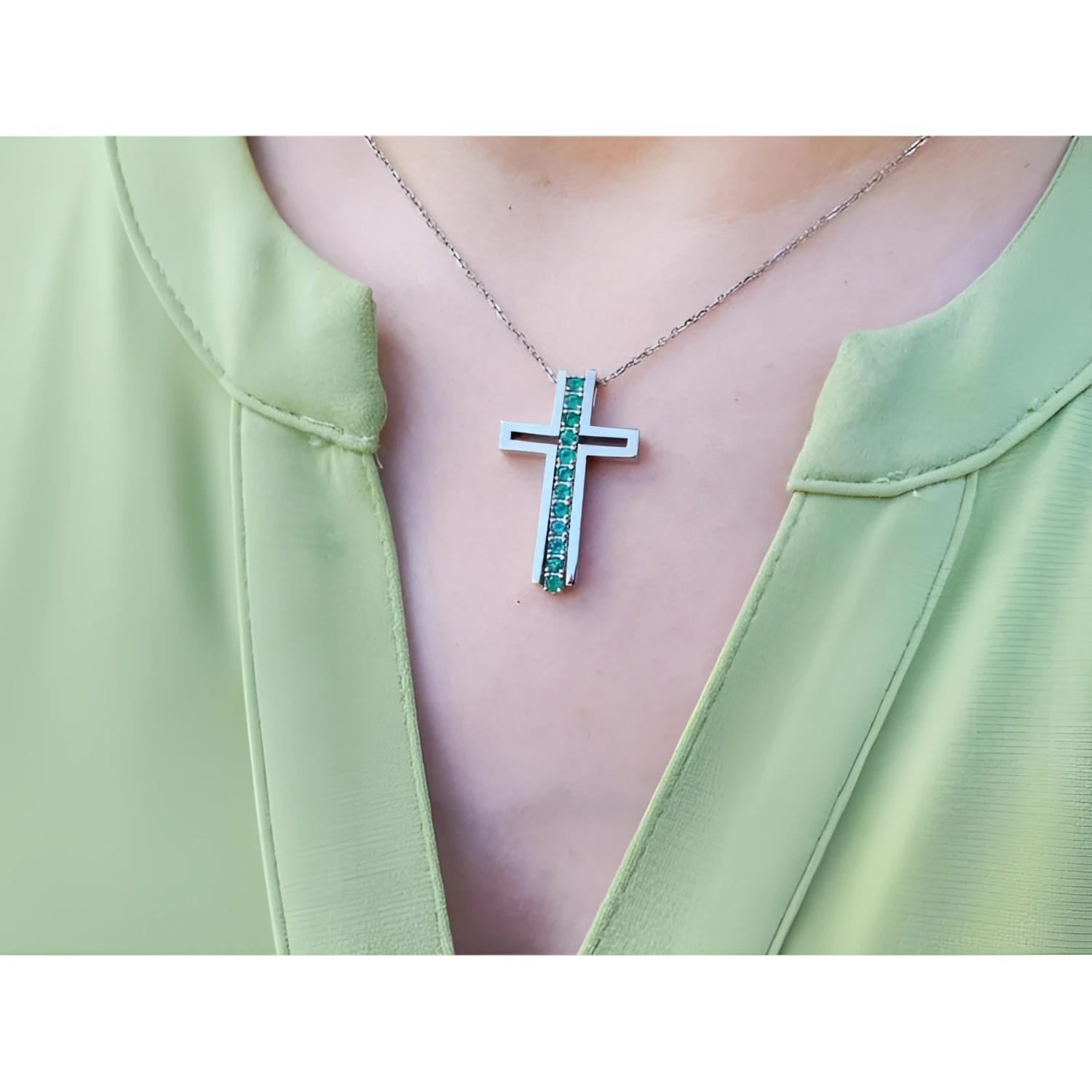 14K white gold cross pendant with round-cut Colombian emeralds on a delicate chain.