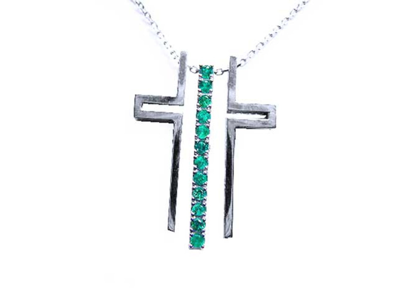 An unassembled white gold cross pendant with natural round emeralds on a white background.