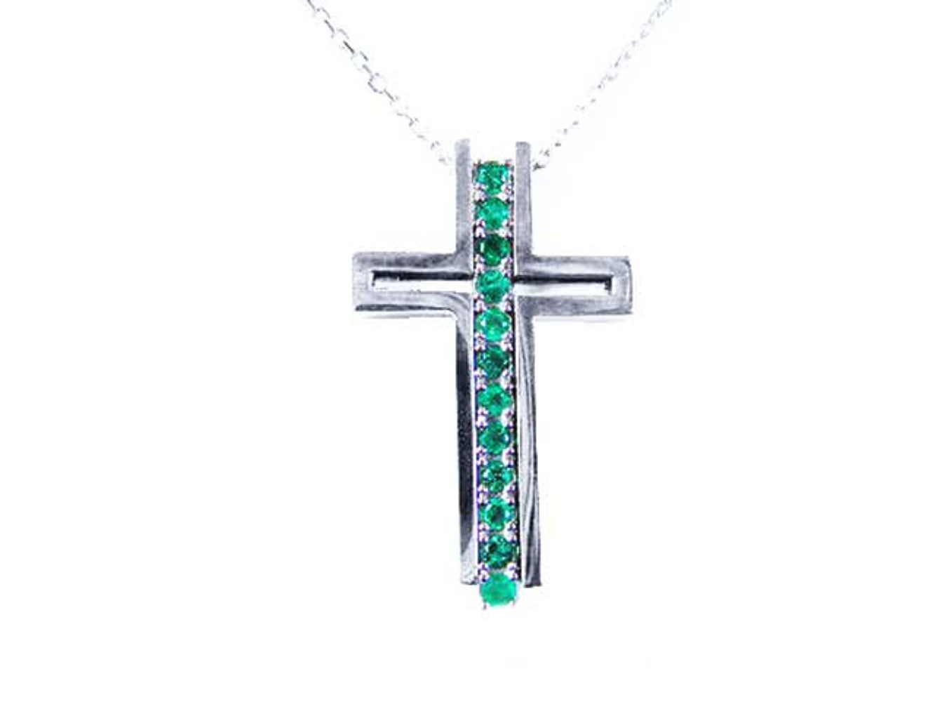 A white gold cross pendant with colombian emeralds on a topside view position.