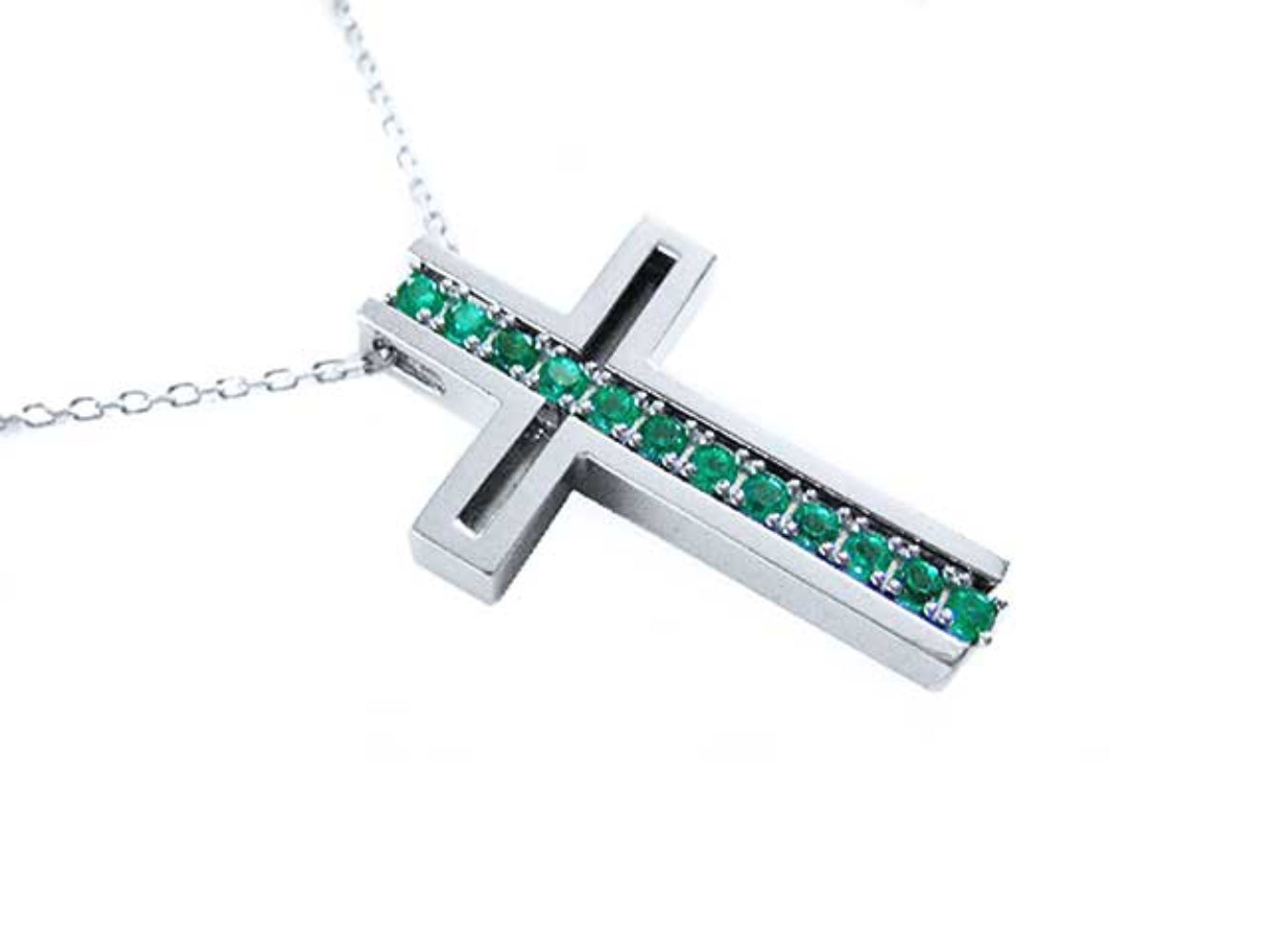 A cross-shaped pendant necklace with round cut emeralds prong set in 14K white gold.