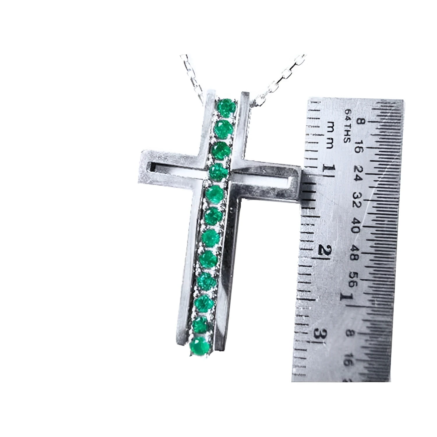 14K white gold cross pendant with 0.50 ct. round Colombian emeralds, shown with a ruler for size.
