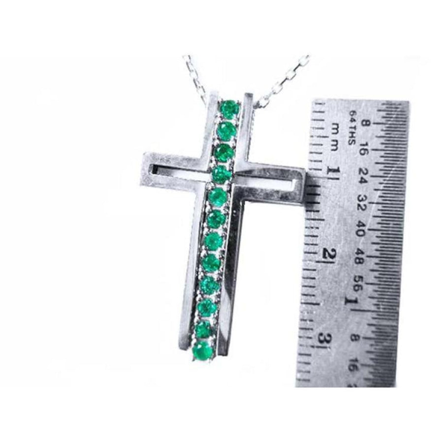 14K white gold cross pendant with 0.50 ct. round Colombian emeralds, shown with a ruler for size.