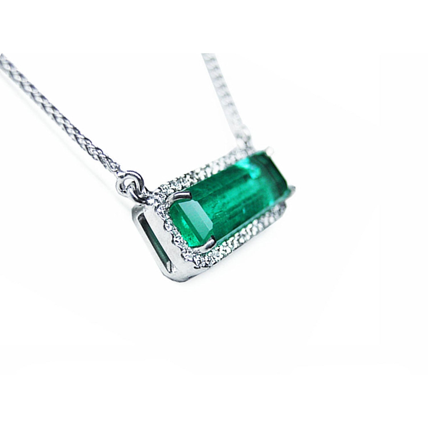 Elongated colombian emerald gemstone necklace encircled in a halo natural diamonds with white gold chain.